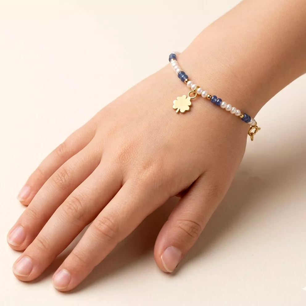 18kt yellow gold baby bracelet featuring alternating freshwater pearls, sapphire beads, and a dangling clover charm
